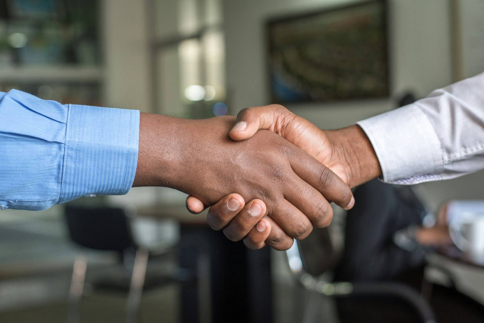 Conseiller GEST'IMMO et client se serrant la main